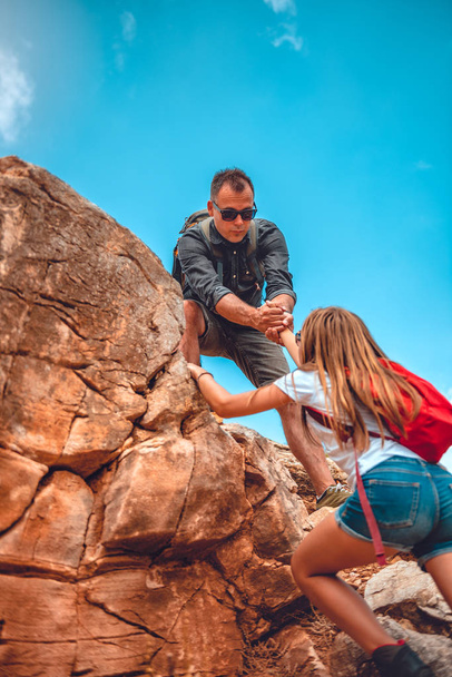 Père et fille grimpent sur la falaise
 - Photo, image