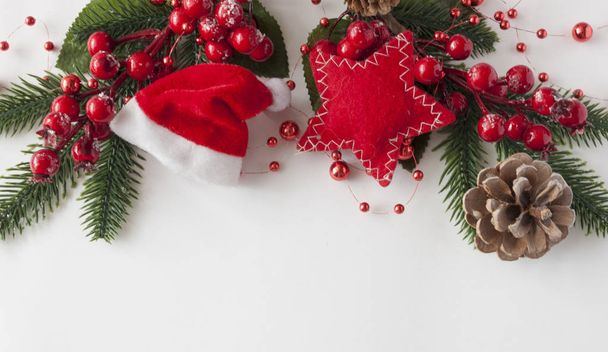 Χριστουγεννιάτικες μπάλες, μούρα και κώνους με αντιγραφικό χώρο σε λευκό παπά - Φωτογραφία, εικόνα