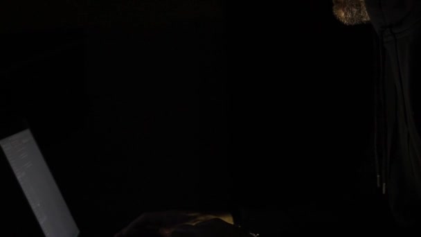 Kapüşonlu sakallı bir bilgisayar korsanı gece vakti karanlık odada hackliyor. Boşluğu kopyala - Video, Çekim