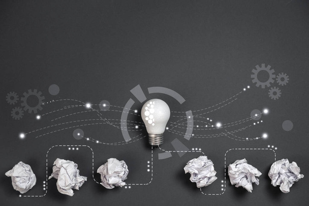 Innovation concept. Crumpled office paper and white light bulb future technologies and network connection on virtual interface background, innovative technology in science and communication concept - Photo, Image