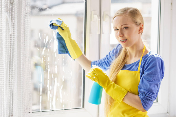 Woman cleaning window at home - Foto, imagen