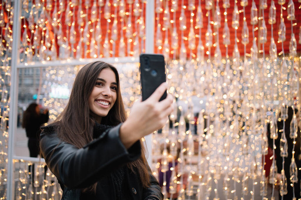 Close-up of woman holding phone and making selfie - Фото, зображення
