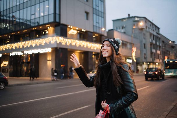Smiling girl with hat waving for taxi - Valokuva, kuva