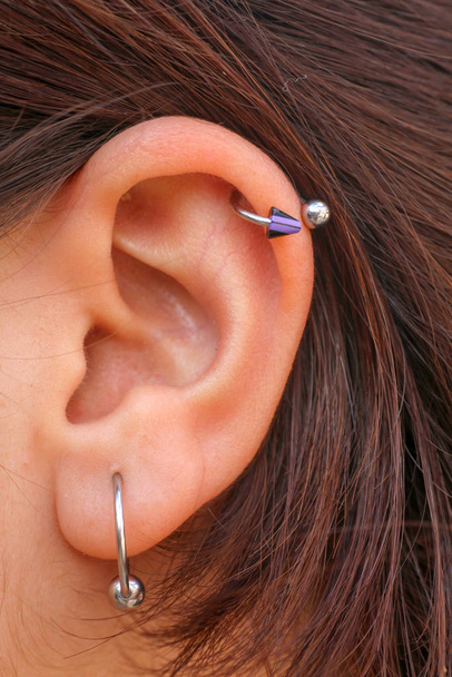 δύο διαφορετικά σκουλαρίκια στο αυτί κυρία - Φωτογραφία, εικόνα