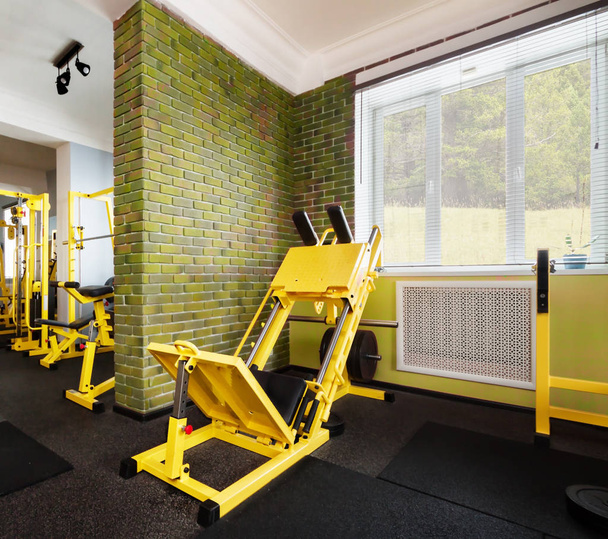 Intérieur de la nouvelle salle de gym moderne lumière dans les couleurs vertes avec équipement jaune
 - Photo, image