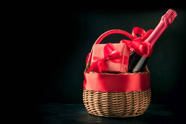 Gift hamper, red gift, bottle of champagne on black. Isolated. Romantic present. - Φωτογραφία, εικόνα