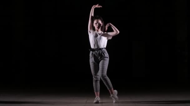 joven mujer bailando vogue, hip hop, baile callejero en el estudio sobre un fondo negro, aislado
 - Metraje, vídeo