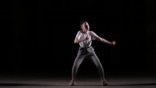 молодая женщина танцует моду, хип-хоп, уличные танцы в студии на черном фоне, изолированные
 - Кадры, видео