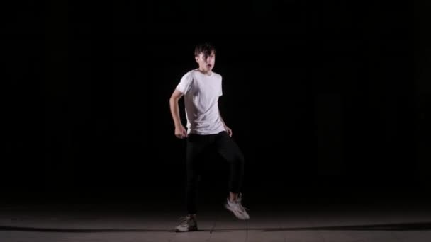 fiatal táncos tánc break dance, hip hop, street dance a stúdióban egy fekete háttér, elszigetelt - Felvétel, videó
