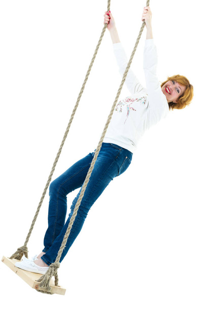 beautiful young woman on a swing against white studio backgroun - Fotoğraf, Görsel