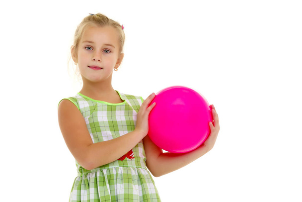 Little girl is playing with a ball - Фото, зображення
