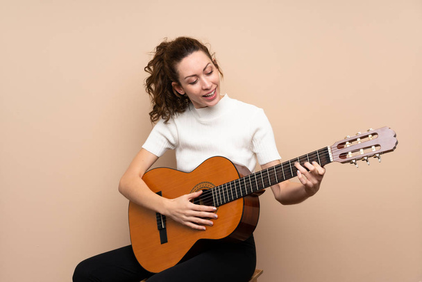 Young woman with guitar over isolated background - Foto, afbeelding