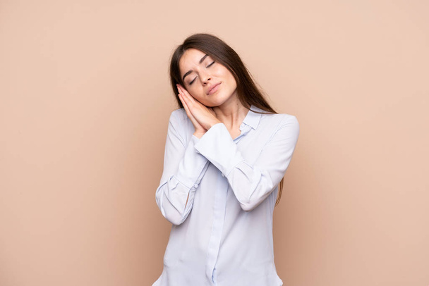 Young woman over isolated background making sleep gesture in dorable expression - Φωτογραφία, εικόνα