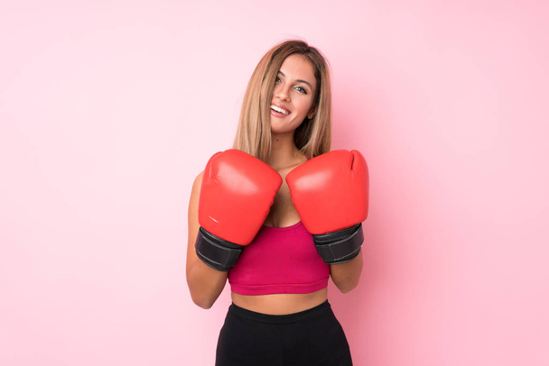 Fiatal sport szőke nő izolált rózsaszín háttér boksz kesztyű - Fotó, kép