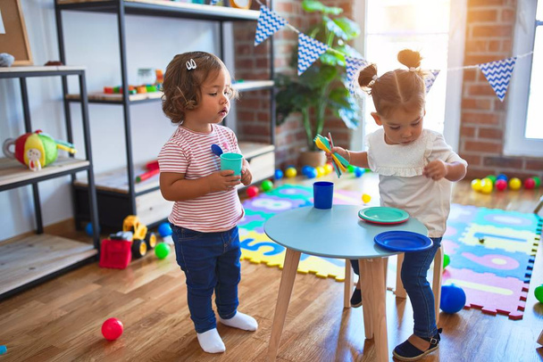 Crianças adoráveis jogando refeições usando alimentos de plástico e brinquedo de talheres no jardim de infância
 - Foto, Imagem
