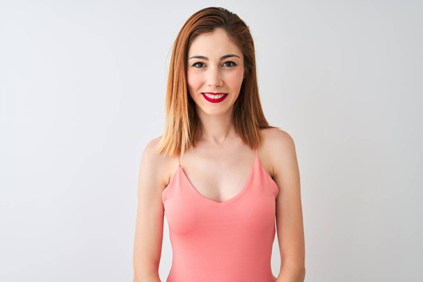 Beautiful redhead woman wearing casual pink t-shirt standing over isolated white background with a happy and cool smile on face. Lucky person. - Foto, afbeelding