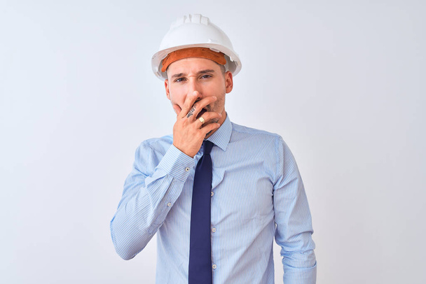 Young business man wearing contractor safety helmet over isolated background bored yawning tired covering mouth with hand. Restless and sleepiness. - Foto, immagini
