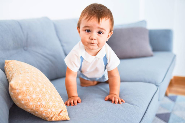 Suloinen lapsi istuu sohvalla kotona
 - Valokuva, kuva