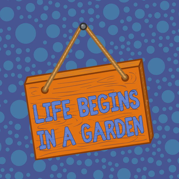 Word writing text Life Begins In A Garden. Business concept for Agriculture Plants growing loving for gardening Square rectangle unreal cartoon wood wooden hang down on the coloured wall. - Photo, Image