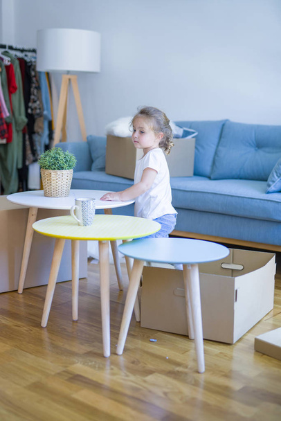 Beautiful toddler child girl playing with boxes at new home - Foto, imagen