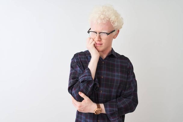 Nuori albiino vaalea mies yllään rento paita ja lasit yli eristetty valkoinen tausta näyttää stressaantunut ja hermostunut kädet suulla puree kynnet. Ahdistuneisuusongelma
. - Valokuva, kuva