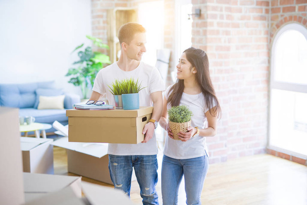 Young beautiful couple  at new home around cardboard boxes - Foto, Imagem