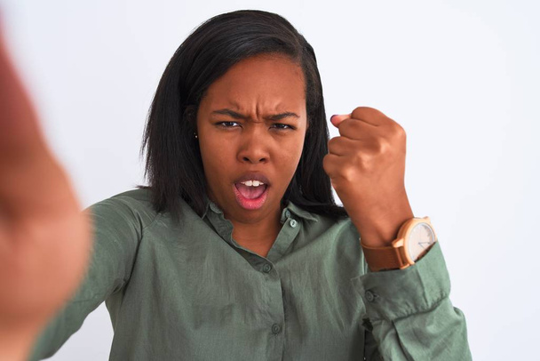 Beautiful young african american woman taking selfie over isolated background annoyed and frustrated shouting with anger, crazy and yelling with raised hand, anger concept - Foto, Bild
