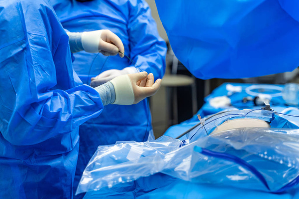 Surgery process. Group of surgeons in operating room with surgery equipment. Selective focus. Crop. Modern medical background. Closeup - 写真・画像