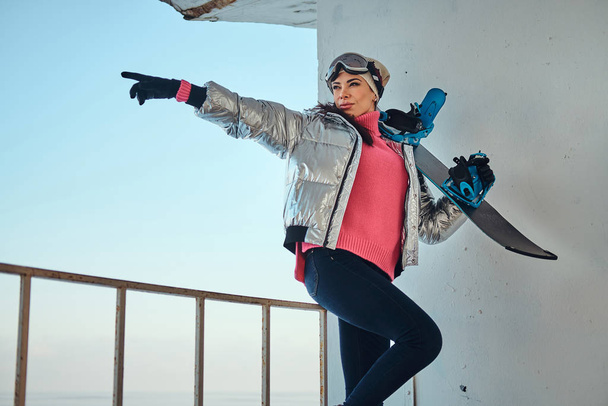 Senhora encantadora com snowboard está posando para fotógrafo
 - Foto, Imagem