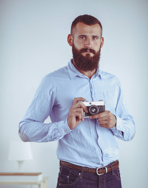 Portrait of a handsome young man holding a camera - Fotoğraf, Görsel