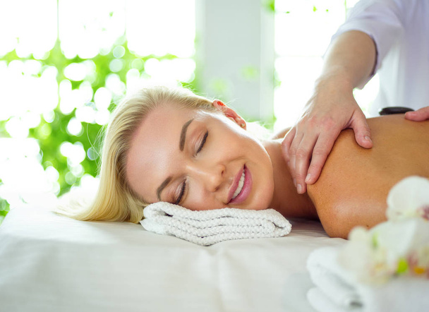 Young woman in spa salon, getting stones massage - Фото, зображення