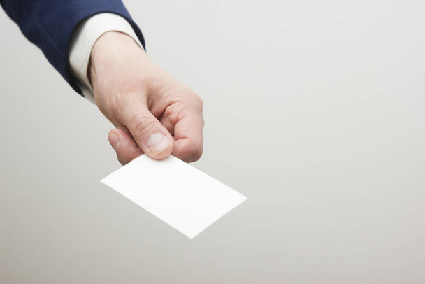 Hand holding white business card on white background - Valokuva, kuva