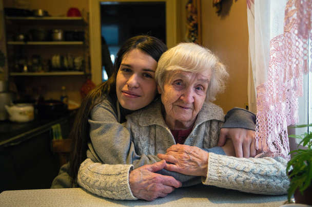 Una anciana con una nieta adulta en una casa de pueblo
. - Foto, Imagen