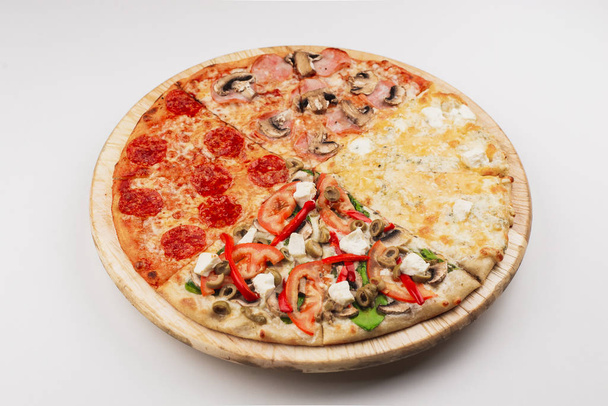 Шматки італійської традиційної піци з беконом, соусами з пепероні, оливками, грибами та сиром на дерев "яній тарілці. - Фото, зображення