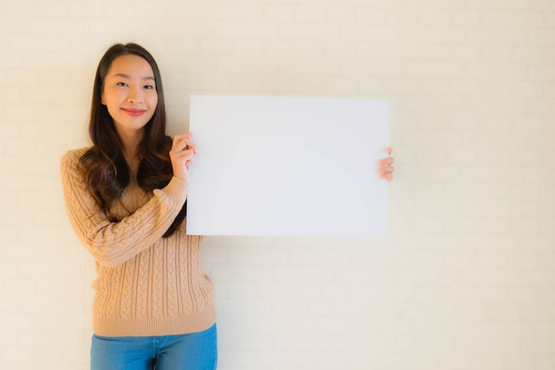 Portré gyönyörű fiatal ázsiai nők mutatják üres fehér papír vaddisznó - Fotó, kép