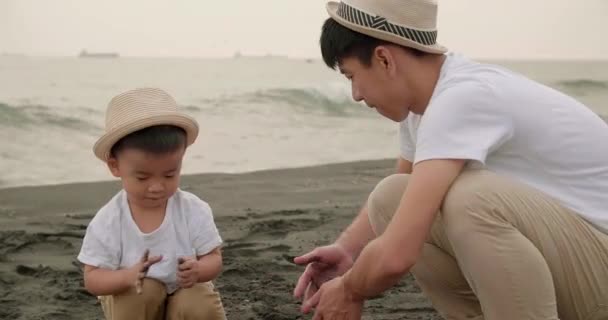 šťastný asijské rodina baví na pláži - Záběry, video