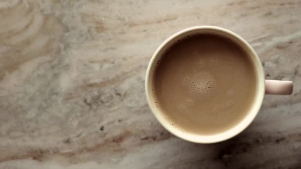 Ochtend koffiekopje met melk op marmeren steen plat leggen, warme drank op tafel plat, top view food videografie en recept inspiratie voor het koken vlog - Video