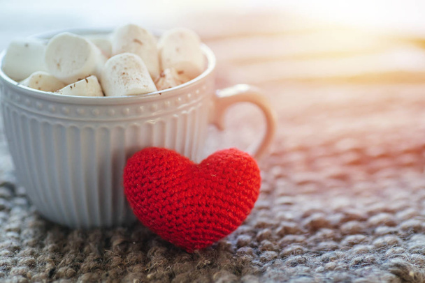 Tasse Kaffee für einsame Liebhaber. Konzept des Valentinstags. Morgens Kakao mit Marshmallows zum Frühstück. großes gehäkeltes rotes Herz. Romantisches Frühstück. - Foto, Bild
