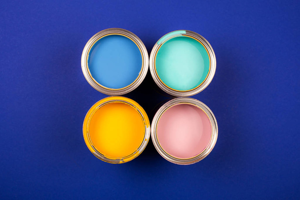Four open cans of paint with brushes on bright background. - Φωτογραφία, εικόνα