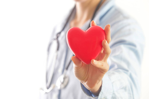 Medische werknemer met een rood hart als symbool van gezondheid, gezondheidszorg concept - Foto, afbeelding