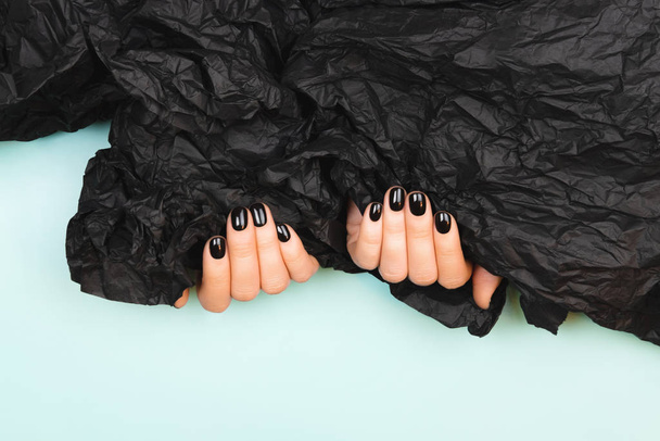 Black manicure with crumpled paper - Фото, зображення