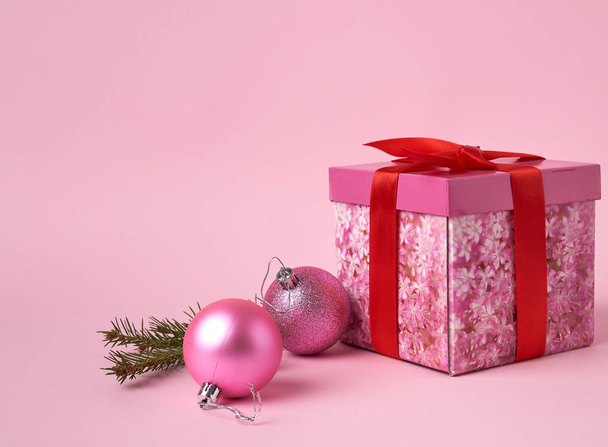 vaaleanpunainen lahjapaketti keula, vihreä kuusi haara ja kaksi koriste p
 - Valokuva, kuva