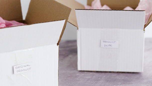 original product vs dupe imitation label on delivery parcel boxes from online purchases and camera panning from one to the other, concept of competition and knock-off items - Footage, Video