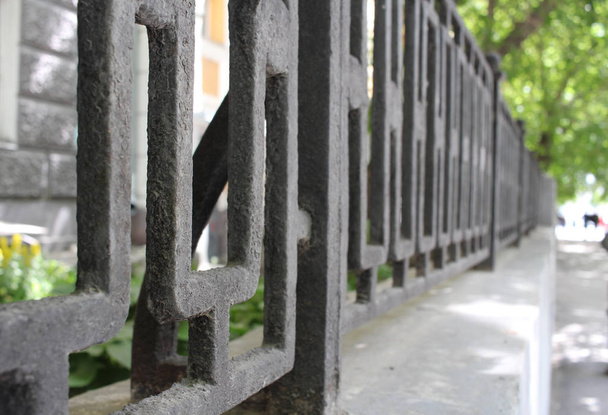 a fragment of an old metal fence from a decorative fence on the street - Fotoğraf, Görsel
