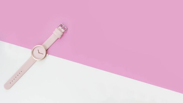 zblízka růžové náramkové hodinky na růžovém a bílém pozadí - Fotografie, Obrázek