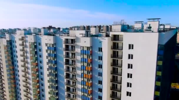 Hoge gebouwen met kleurrijke gacades in nieuwe moderne stadswijk. Beweging. Vliegen in de buurt van ontwikkelingsgebied met nieuwe woningen. - Video