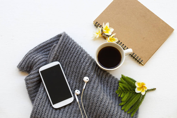 notebook, mobilní telefon, káva a pletení vlněná šála životního stylu žena relaxovat v zimní sezóně dekorace na pozadí bílé dřevěné - Fotografie, Obrázek