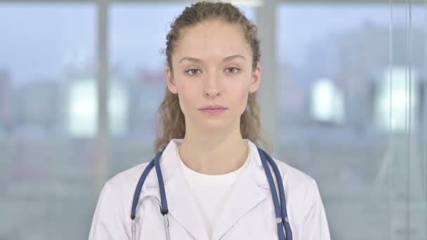 Πορτρέτο του χαμογελώντας νεαρή γυναίκα γιατρός κοιτάζοντας την κάμερα - Πλάνα, βίντεο