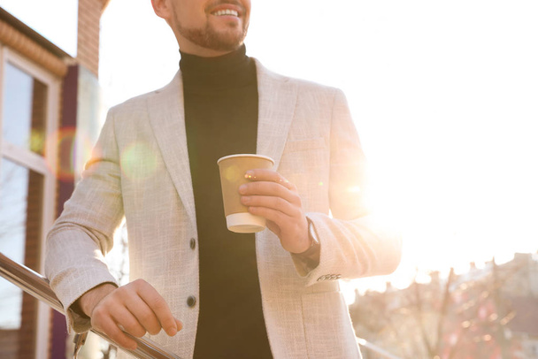 Businessman with cup of coffee on city street in morning, closeu - Zdjęcie, obraz