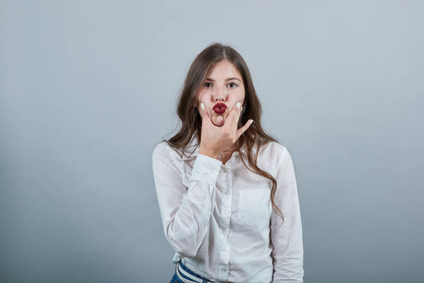 Mujer joven caucásica, toma las manos en las mejillas, las aprieta, haciendo pucheros labios
 - Foto, Imagen